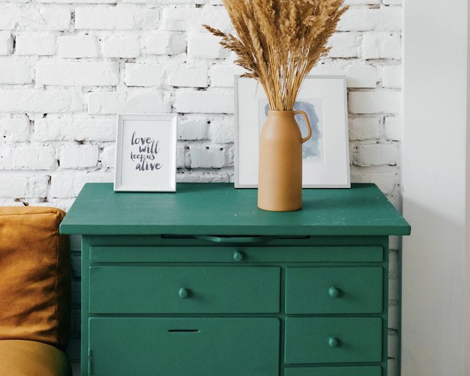 A green drawer with a flower vase on top